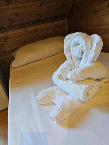 a white towel sitting on top of a bed at Bujtina Guri Hanit in Ferr-Shkopet