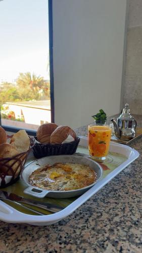 a tray with a plate of food and bread on a counter at Nomad Surf Hotel in Tamraght Ouzdar