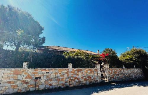 a brick wall next to a house with a mountain at Steno Villa Amoudi in Amoudi