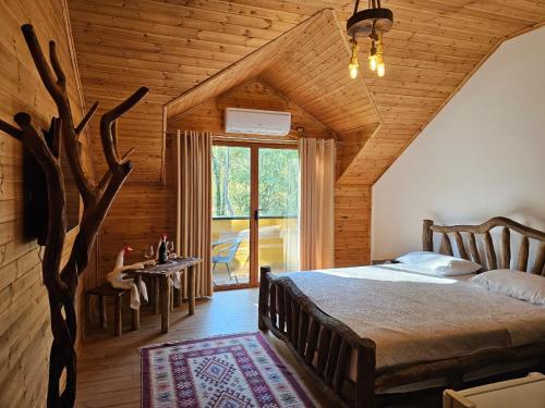 a bedroom with a bed and a tree in a room at Bujtina Guri Hanit in Ferr-Shkopet