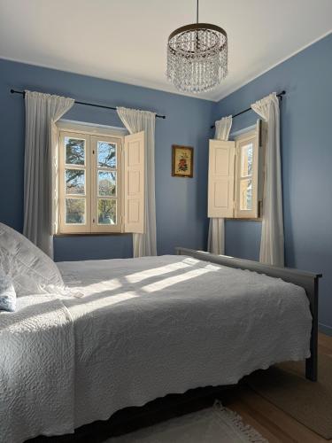 a blue bedroom with a bed and a chandelier at Jardim de Cascais in Cascais