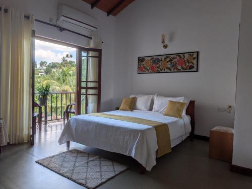 a bedroom with a large bed and a balcony at Windy Ridge Kandy in Kandy