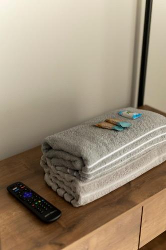 a stack of towels on a table with a remote control at 108-Studio funcional com treliche prox UEL in Londrina