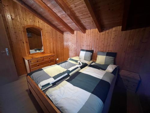 a bedroom with a bed in a wooden cabin at Gemütliches Chalet mit Kamin&Seeblick in Oberterzen Flumserberg in Oberterzen