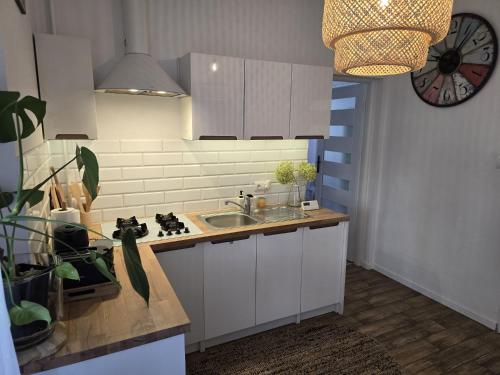 een keuken met een wastafel en een klok aan de muur bij Apartamenty CAPPUCCINO in Przemyśl