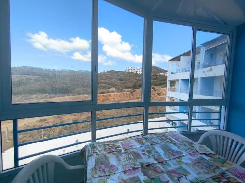 卡博尼格洛Cabo Dream的一间有桌子、椅子和窗户的房间