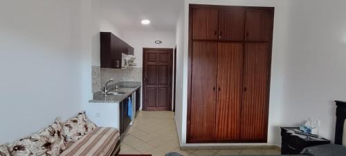 卡博尼格洛Cabo Dream的厨房里有一张沙发和一个木制橱柜