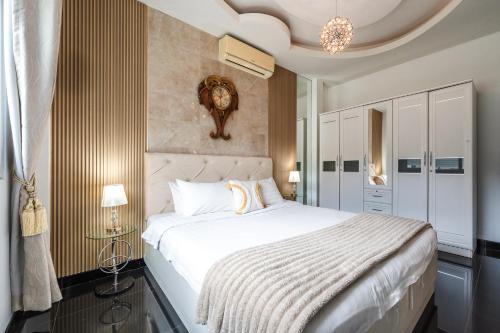 una camera da letto con un letto grande e un lampadario di Platinum Villa Rawai 76 a Rawai Beach