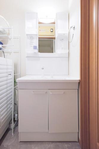a white kitchen with a microwave on a counter at Kamakura Hase House in Kamakura