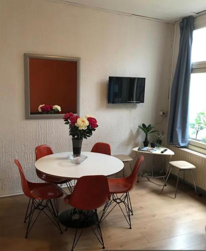 a room with a table with a vase of flowers on it at Old City Centre in Breda