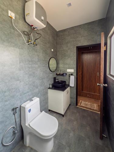 a bathroom with a toilet and a sink at Villa Kaavan in Rāmgarh