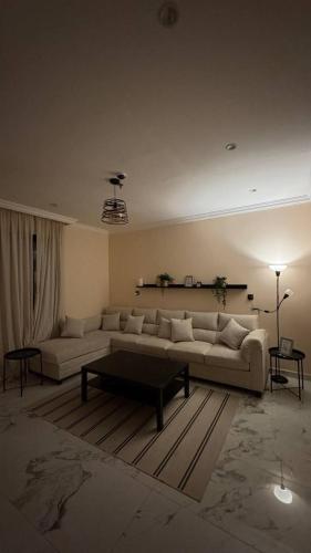 a living room with a couch and a coffee table at نسمة الخبر سويت in Dammam