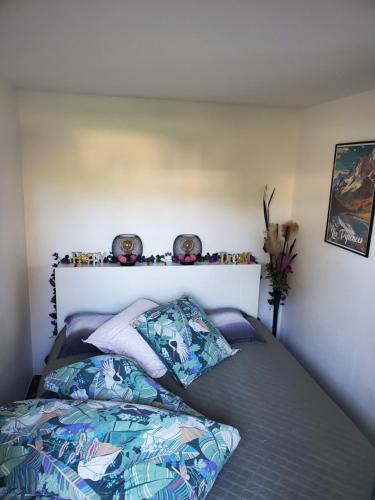 een slaapkamer met een bed met een dekbed en kussens bij APPT Cosy entier avec piscine in Toulouse