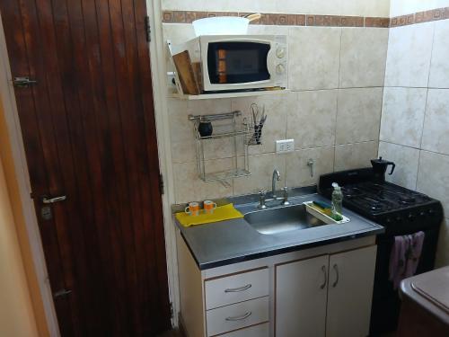 a small kitchen with a sink and a microwave at Lo de Alfonso in San Bernardo