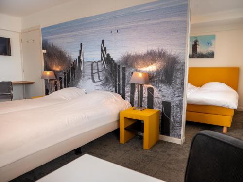 a room with two beds and a mural of a beach at Heeren van Noortwyck in Noordwijk aan Zee