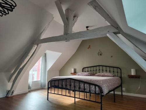 a bedroom with a bed in the attic at La petite maison des choux in Les Choux