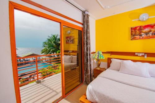a bedroom with a bed and a balcony at Résidence Hôtelière TAZ in Kribi