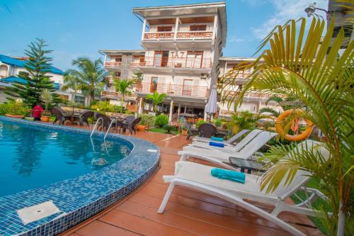 a hotel with a swimming pool and lounge chairs at Résidence Hôtelière TAZ in Kribi