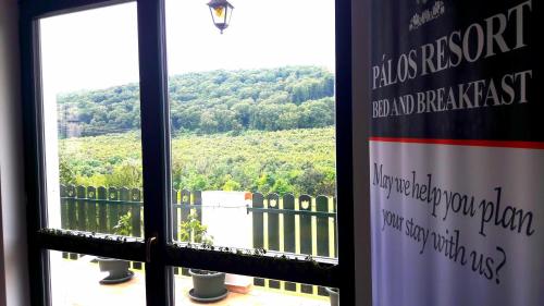 a window with a view of a mountain view at Pálos Resort in Zalacsány