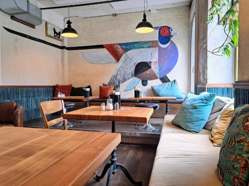 a restaurant with tables and a painting on the wall at Guesthouse fürDich in Zürich