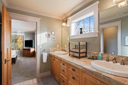 a bathroom with two sinks and a large mirror at Awbrey in Bend
