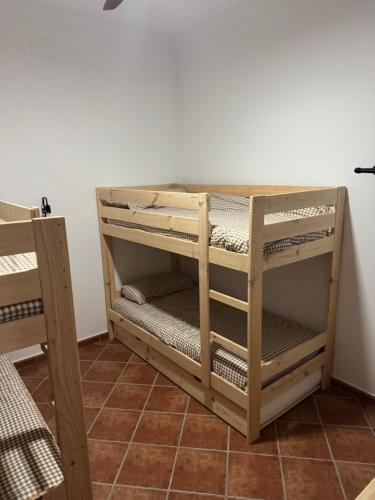 Ein Schlafsaal mit einem hölzernen Etagenbett und einem Regal in der Unterkunft Casa Indalo in La Puebla de los Infantes