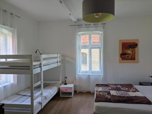a bedroom with two bunk beds and a window at Rathsacks Familienhof in Ziegendorf