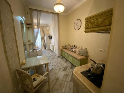 a living room with a couch and a clock on the wall at Old Tbilisi Apart-Hotel in Tbilisi City