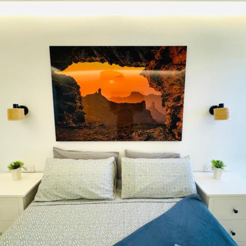 a bedroom with a bed with a painting on the wall at Bungalow Diana in Maspalomas