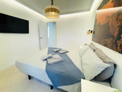 a bedroom with a bed and a couch and a tv at Bungalow Diana in Maspalomas