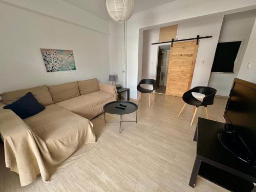 een woonkamer met een bank en een aantal stoelen bij 55sm apartment Voula 4pax in Athene