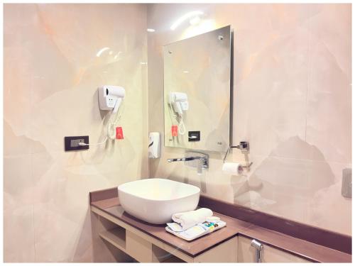 Un baño con un lavabo blanco y un espejo. en Near Jagannatha Temple Puri HGH-Grand Heritage #Rooftop Pool, en Puri