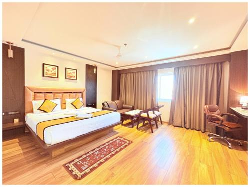 Una habitación de hotel con una cama grande y un escritorio. en Near Jagannatha Temple Puri HGH-Grand Heritage #Rooftop Pool, en Puri