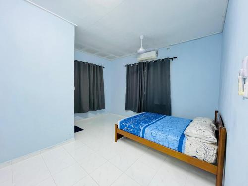 a bedroom with a bed in a room with blue walls at Z Homestay in Kuala Terengganu
