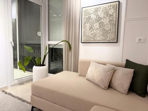 a living room with a couch and a potted plant at Endis House in Shëngjin