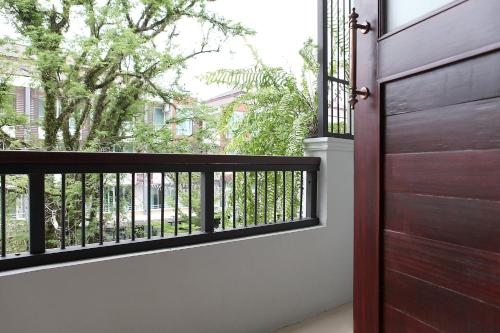 a balcony with a wooden door and a tree at Hogwortz Hostel & Tour in Krabi