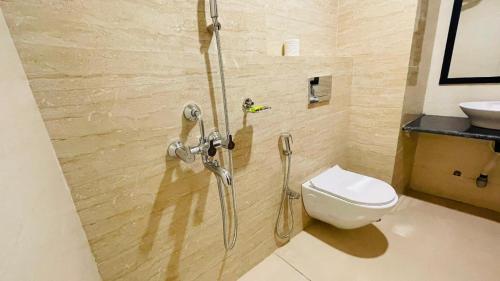 a bathroom with a shower with a toilet and a sink at The Imperia in Guwahati