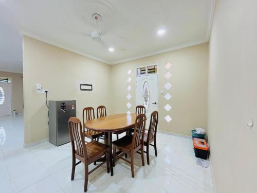 a dining room with a wooden table and chairs at Z Homestay in Kuala Terengganu