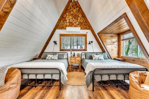 zwei Betten in einem Zimmer mit Dachboden in der Unterkunft High Bear Activity, Handicap Ramp, Hot Tub, Fire Table, Game Room, Family Cabin in Gatlinburg
