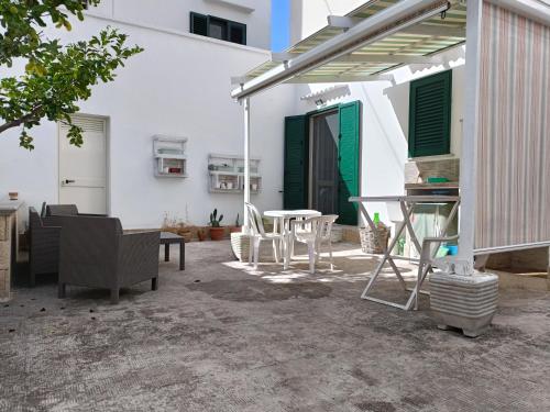 eine Terrasse mit einem Tisch und Stühlen sowie ein weißes Haus in der Unterkunft Dimora Vincenzo in Gallipoli