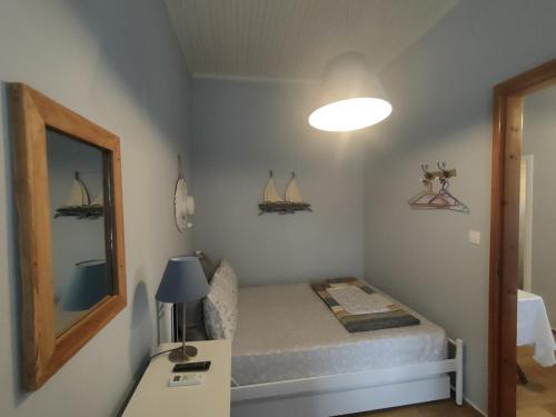 um pequeno quarto com uma cama e um espelho em Sea Side Studio with Balcony and Sea View em Ayía Kiriakí