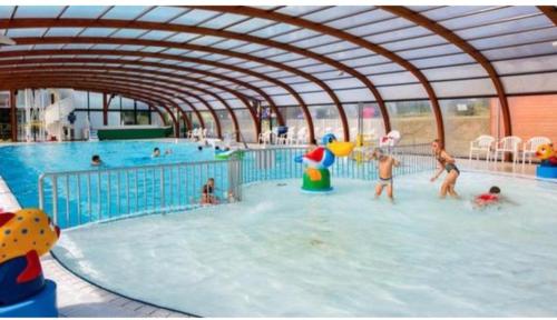 un groupe de personnes jouant dans une piscine dans l'établissement DOMA Mobil home 3 chambres Litteau, à Litteau