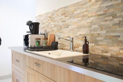 Una encimera de cocina con fregadero y microondas. en L'atypique des choux, en Les Choux