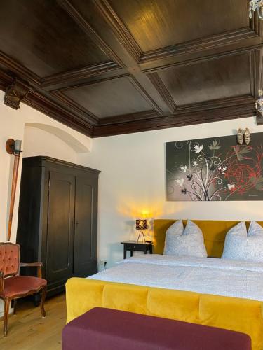 イスニー・イム・アルゴイにあるModerner Altstadttraumのベッドルーム(大型ベッド1台、黄色いソファ付)