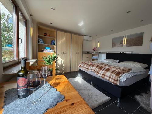 a bedroom with a bed and a table with wine glasses at M-Suites Petit - Near Frankfurt Airport in Hattersheim