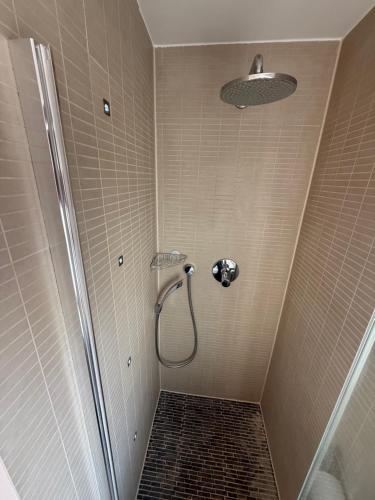 a bathroom with a shower with a tile floor at M-Suites Petit - Near Frankfurt Airport in Hattersheim