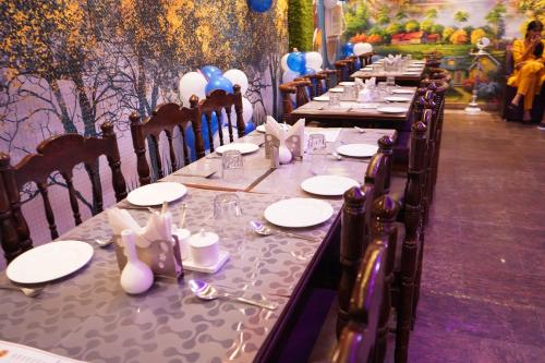 a long table with plates and napkins on it at Hotel BLUE DIAMOND in Begusarai