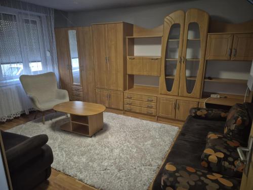 a living room with wooden cabinets and a table and a couch at Tranzit apartman 3 in Odorheiu Secuiesc