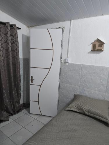 a room with a door and a bed in a room at Aluguel de quarto por diária in São Luís