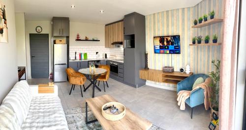 a living room and kitchen with a couch and a table at Table View Escape in Cape Town